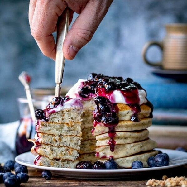 Forkful of Chia hazelnut pancakes with blueberry compote being taken
