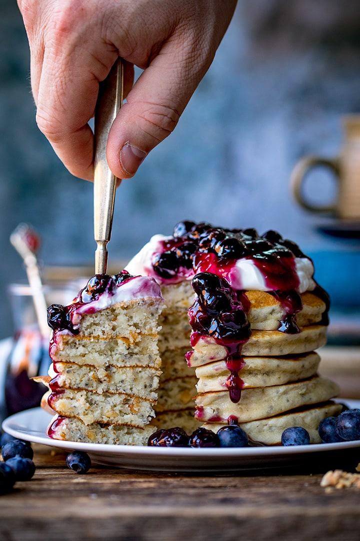 Stack of chia hazelnut pancakes with a forkful being taken