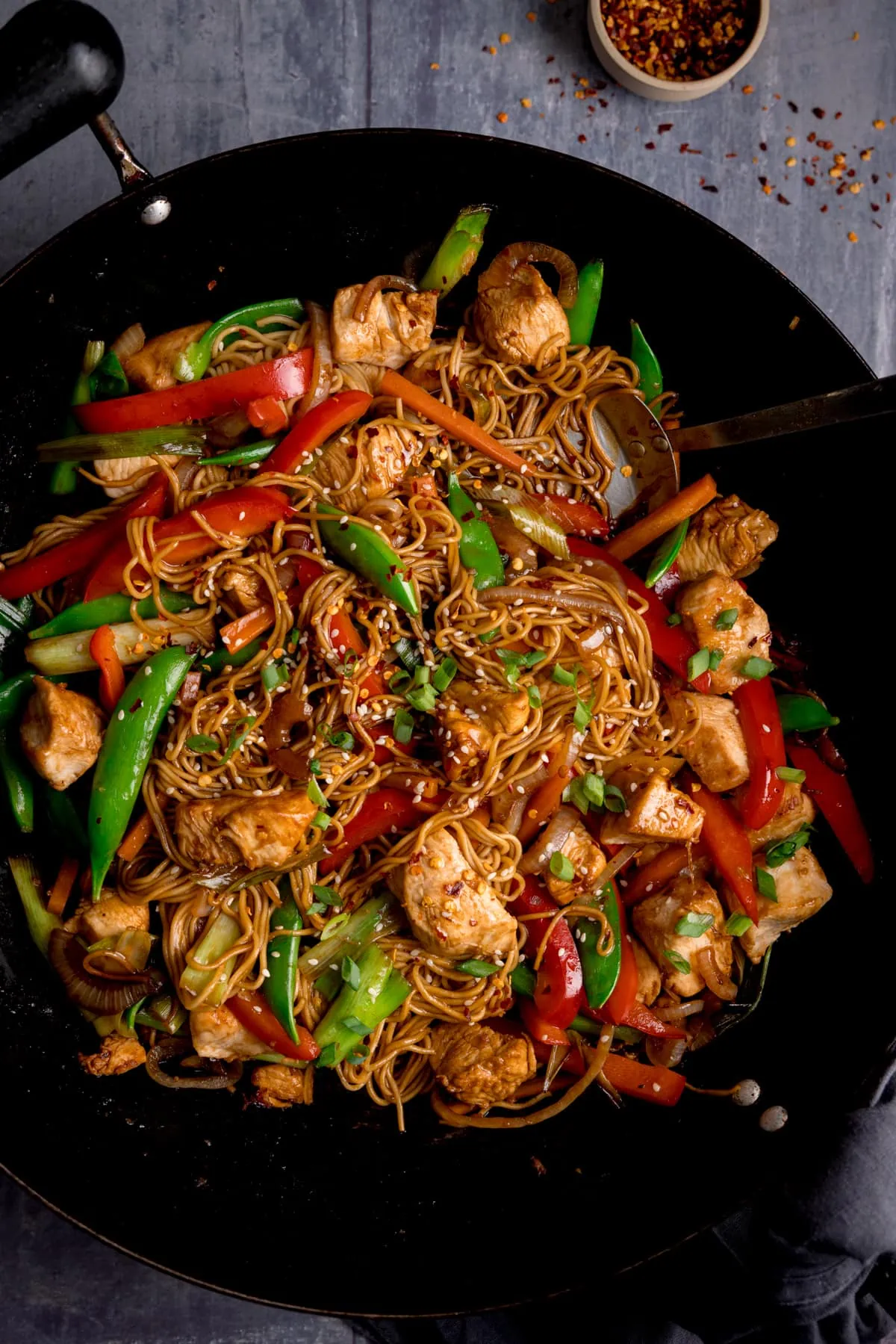 Overhead image of a wok filled with chicken chow mein.