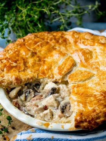 Square image of chicken and mushroom pie with a slice taken out