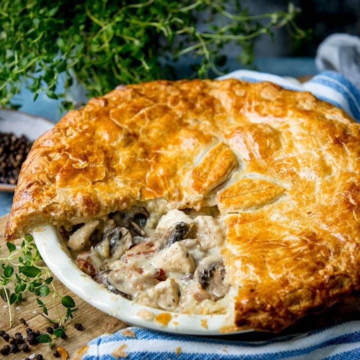 Square image of chicken and mushroom pie with a slice taken out