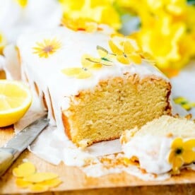 Square image of sliced open lemon drizzle cake