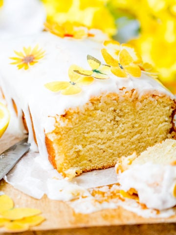 Square image of sliced open lemon drizzle cake