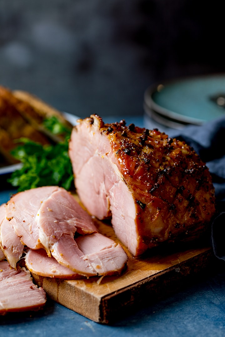 Baked ham with slices taken on a wooden board