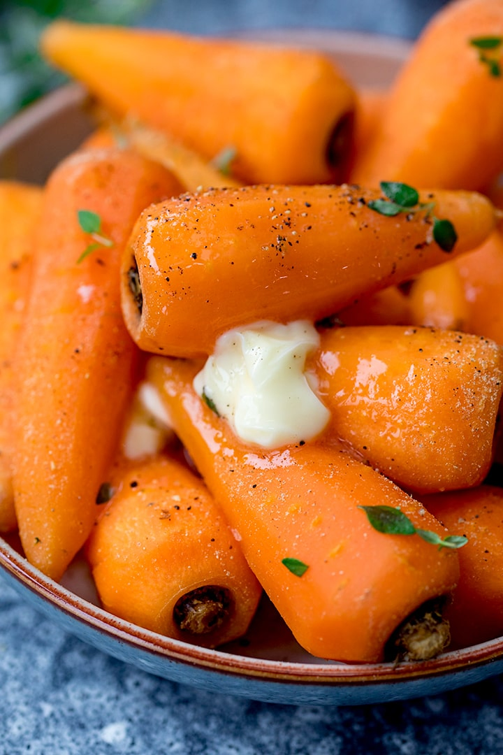 Bowl of steamed carrots with butter and pepper