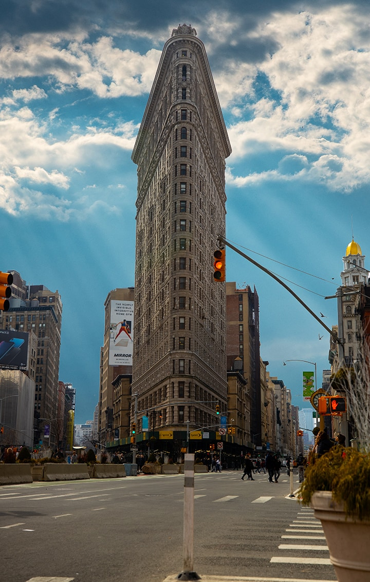 Flat iron building in New York against a blue sky