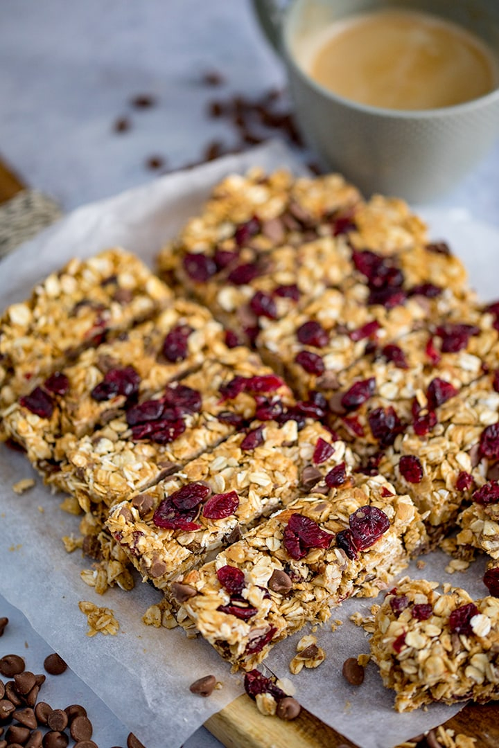 Peanut Butter Granola Bars with cranberries and chocolate chips on a chopping board