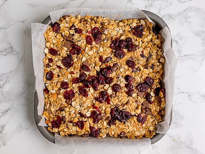 Granola bar mixture in a baking tin on white background