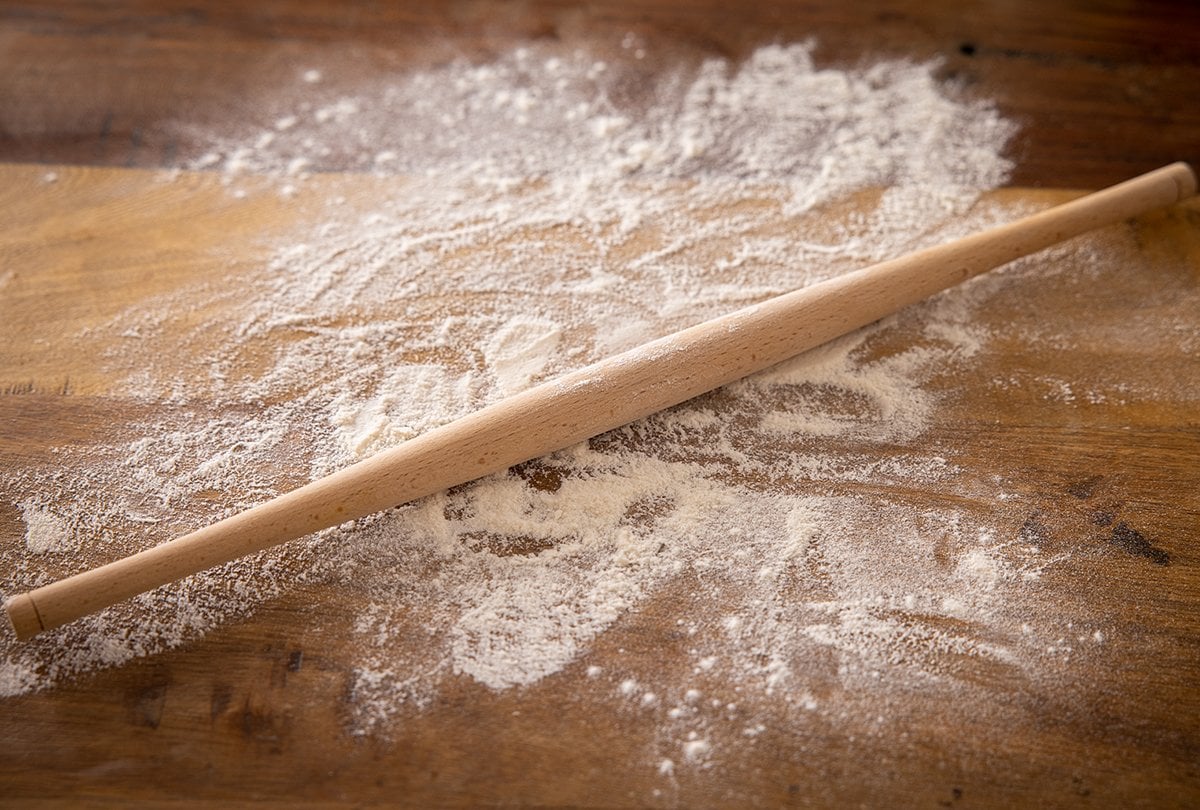 Chapati rolling pin on a flour dusted wooden surface