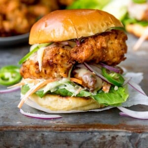 Square image of Crispy chicken burger on a brioche bun with lettuce.