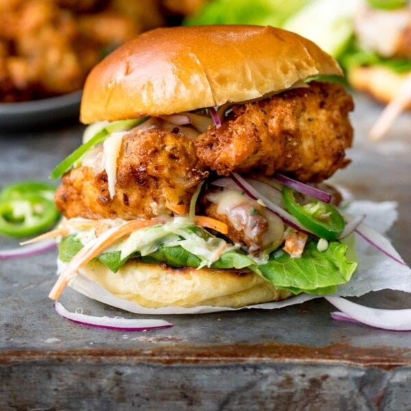 Square image of Crispy chicken burger on a brioche bun with lettuce.