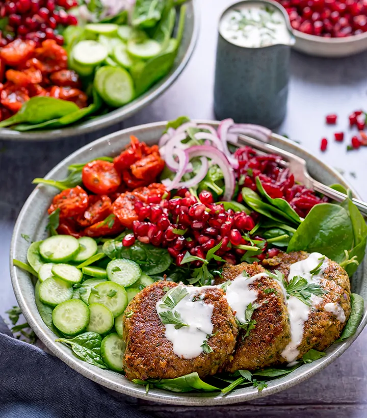 Salad bowl with falafel and feta dressing - little jug of dressing in the background