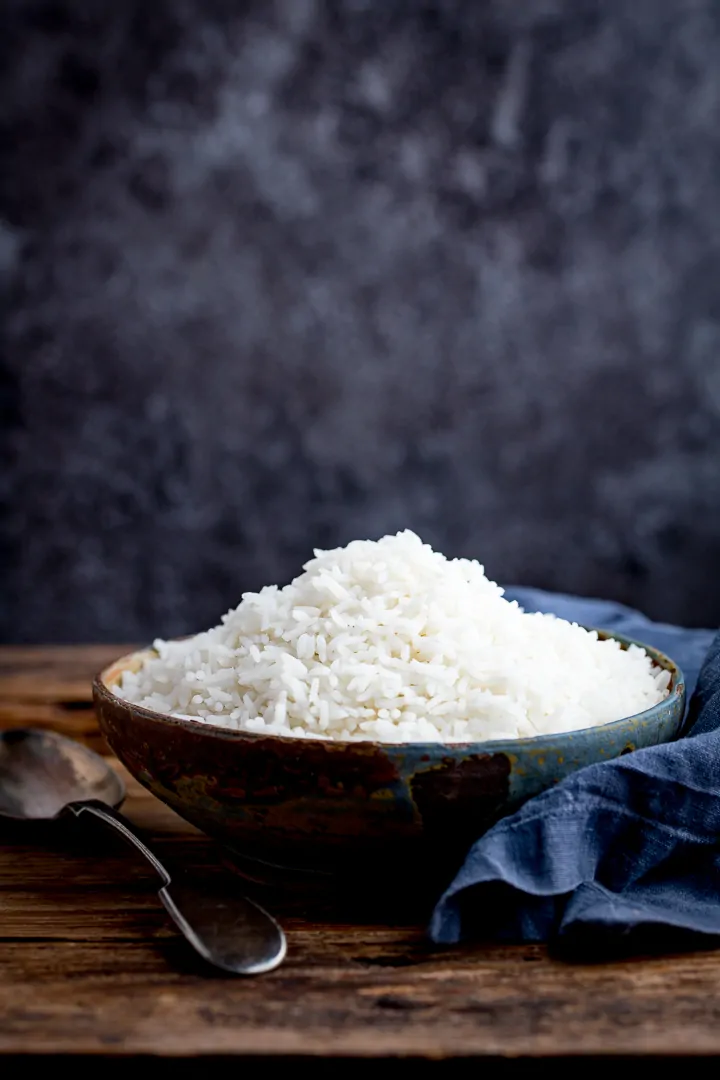 Boiled rice in a bowl on a wooden table