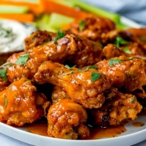 wide image of Buffalo chicken wings on a white plate