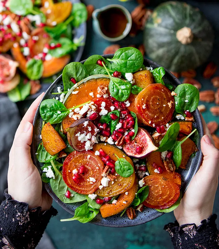 Hands holding a bowl of Roasted acorn squash salad