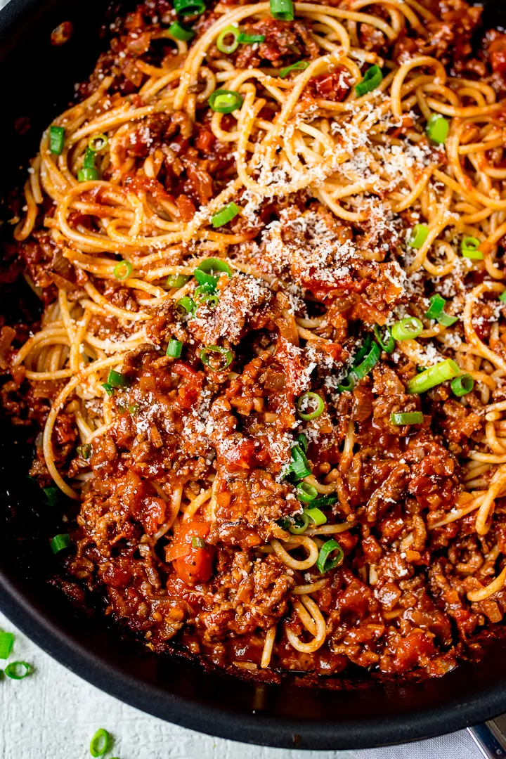 Close up shot of a pan of spaghetti bolognese all mixed together