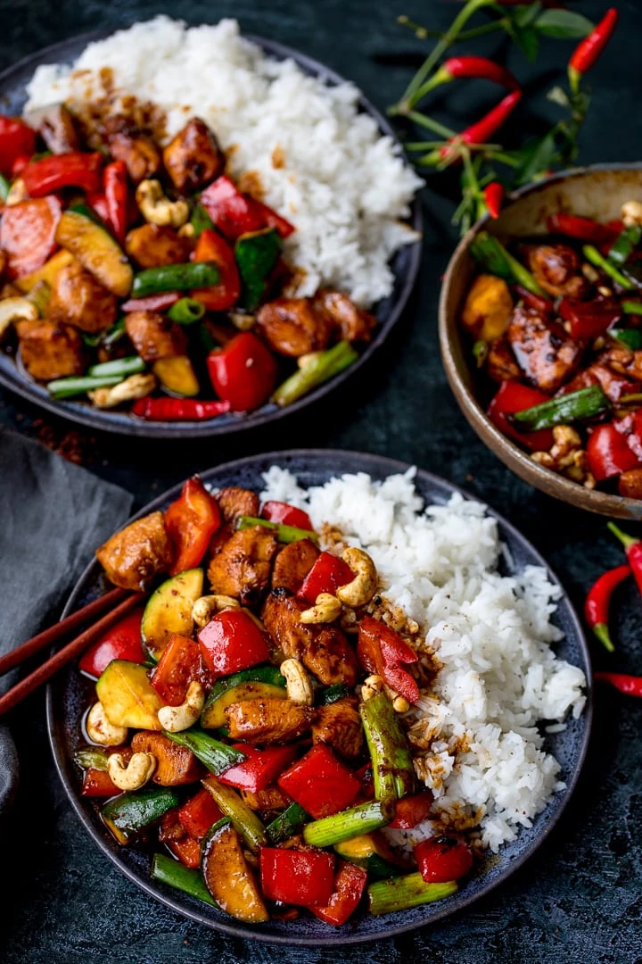Two plates of kung pao chicken with rice