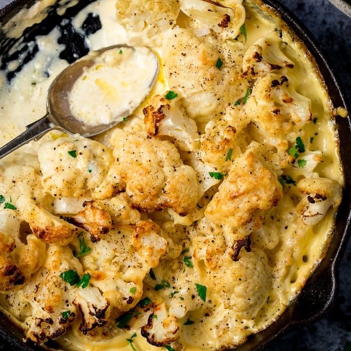 Cauliflower cheese in a pan with a spoon in pan