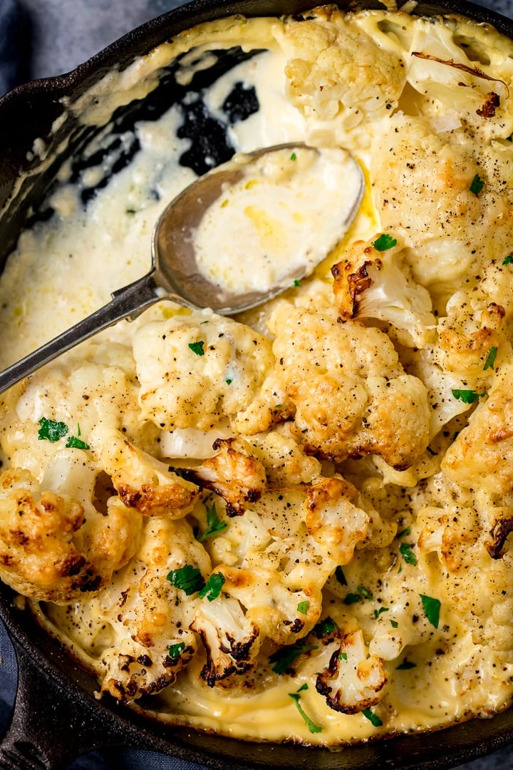 Cauliflower cheese in a pan with a spoon