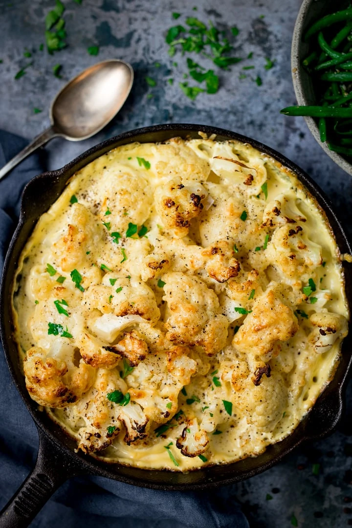 Cauliflower cheese in a pan on a dark background