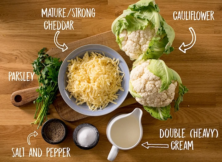 Ingredients for cauliflower cheese on a wooden table