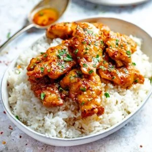 honey garlic chicken in a bowl on top of boiled rice