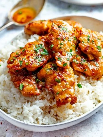 honey garlic chicken in a bowl on top of boiled rice