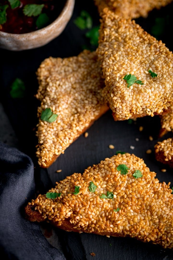 Overhead of prawn toast triangles on a dark backgrouns