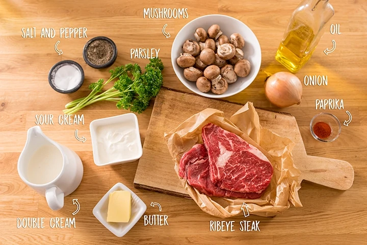 Ingredients for beef stroganoff on a wooden background