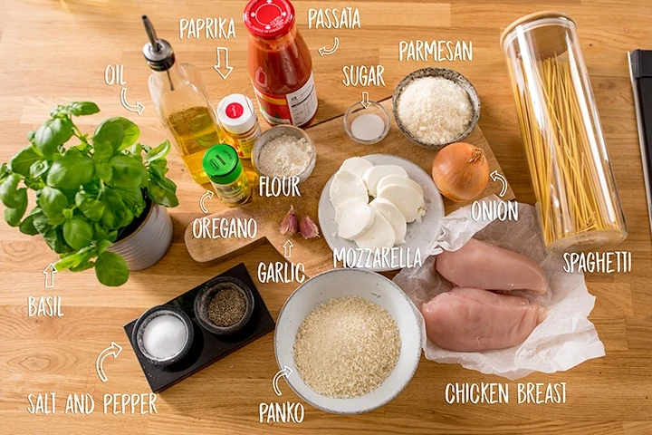 Ingredients for chicken parmesan on a wooden background