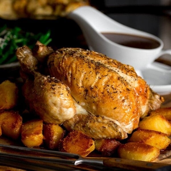 roast chicken on a board with potatoes and gravy