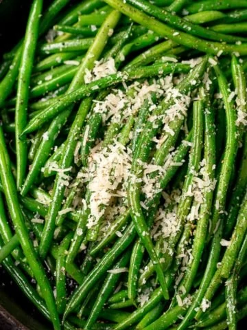 green beans sprinkled with parmesan in a pan