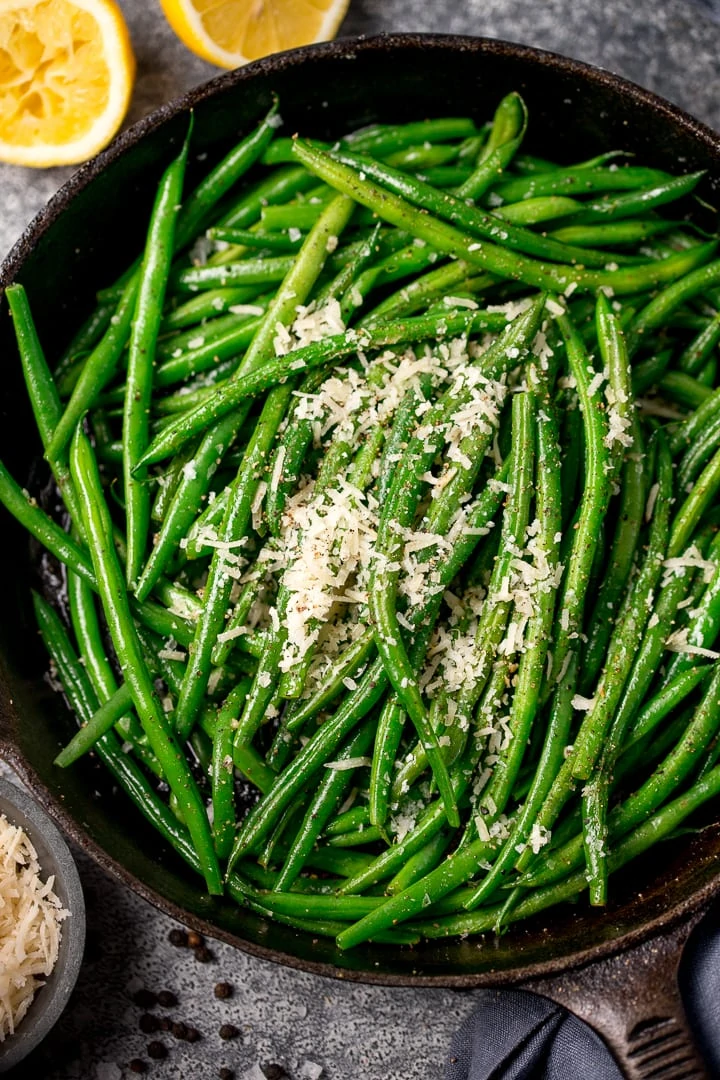 green beans in a pan with parmesan and lemon