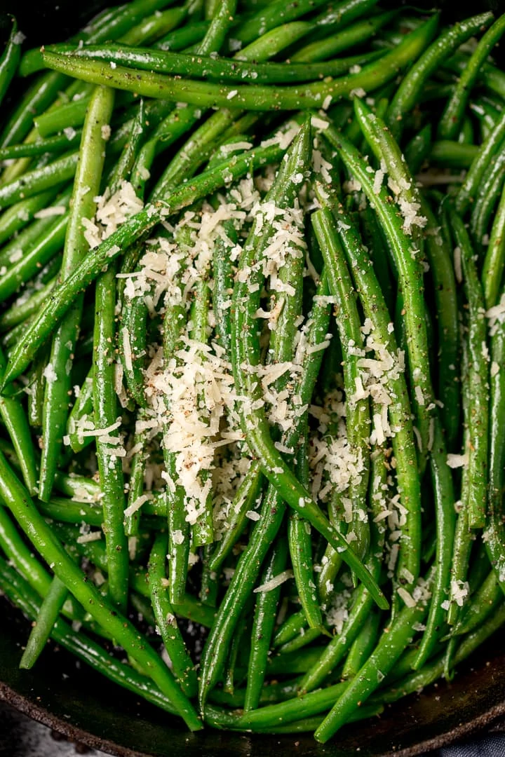 Close up of green beans in a pan with parmesan on top
