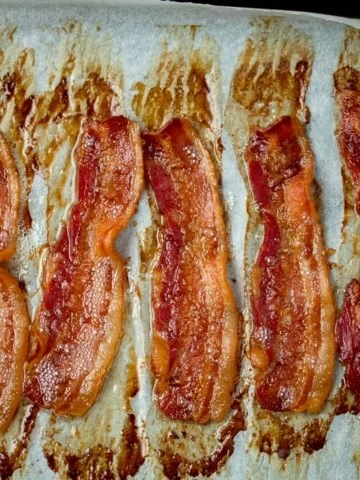Square image of strips of cooked bacon on a tray