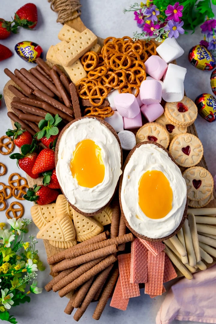 giant creme egg cheesecake dip surrounded by biscuits, marshmallows and strawberries for dipping