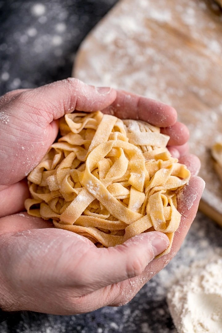 Homemade tagliatelle cupped in two hands