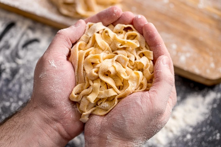 Wide image of Homemade tagliatelle cupped in two hands