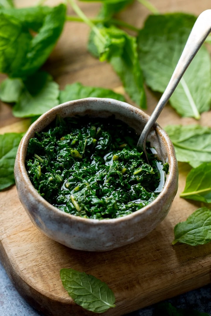 Mint sauce in a small dish with a spoon in the sauce