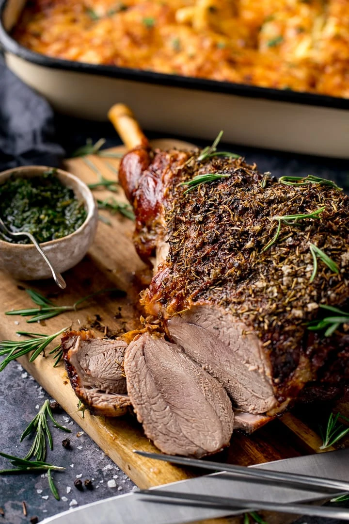 Roast leg of lamb on a board with a couple of slices taken out