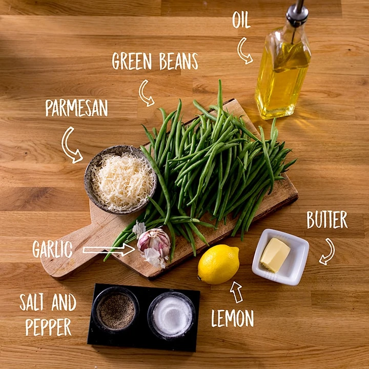 Ingredients for garlic green beans with parmesan on a wooden table