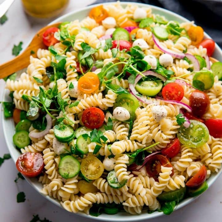 Large bowl filled with pasta salad on a light background