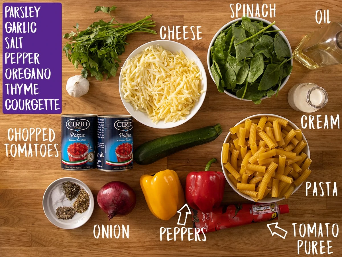 Ingredients for vegetable pasta bake on a wooden table