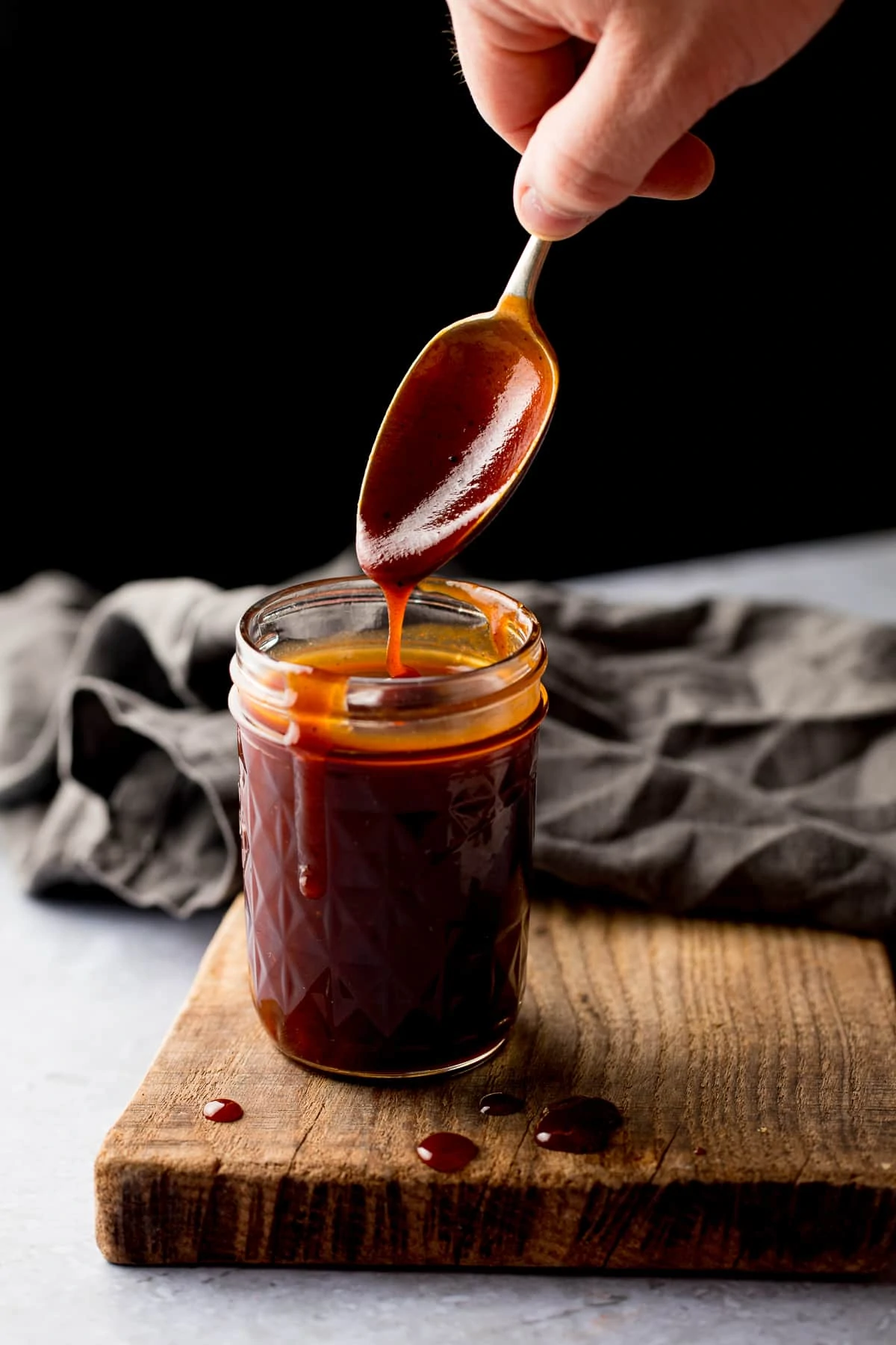 Spoonful being taken from a jar of homemade bbq sauce