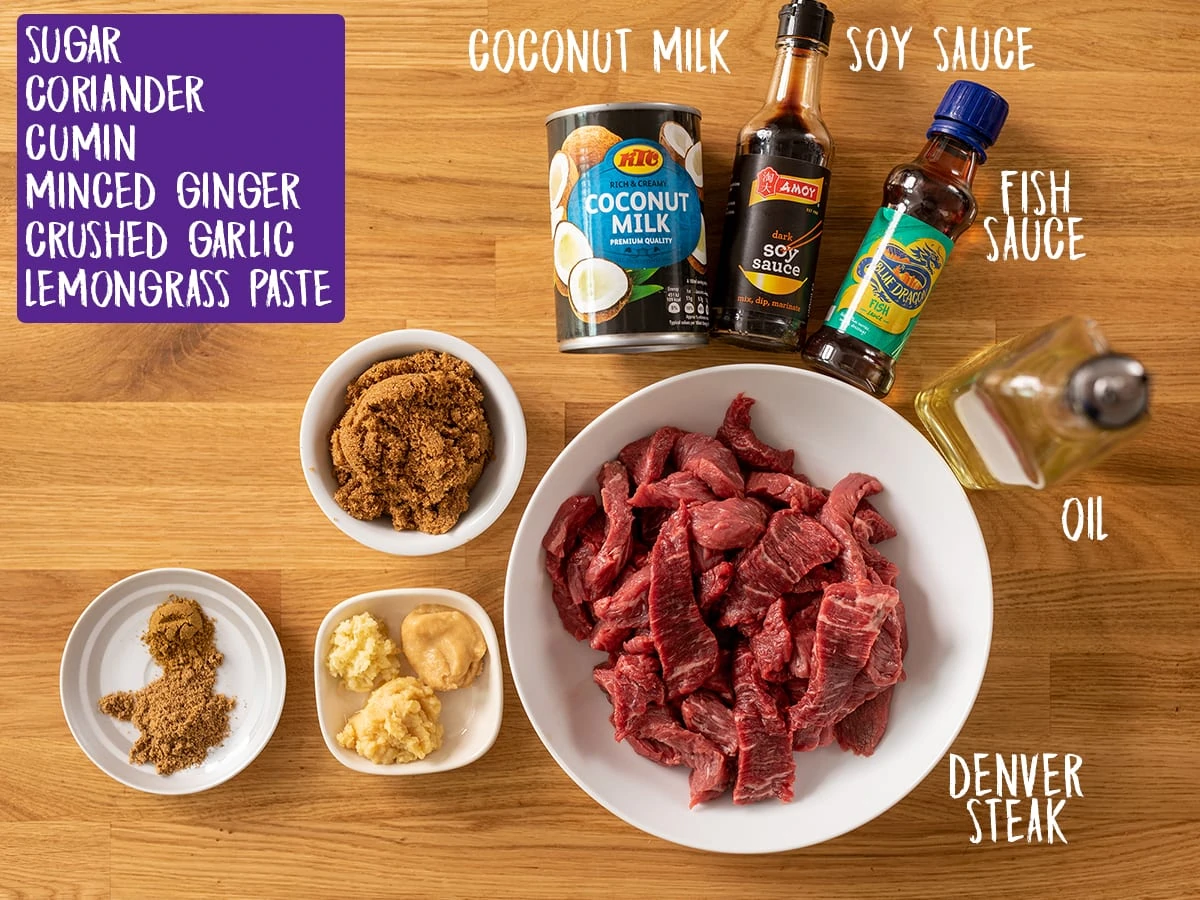 Ingredients to make beef satay on a wooden table