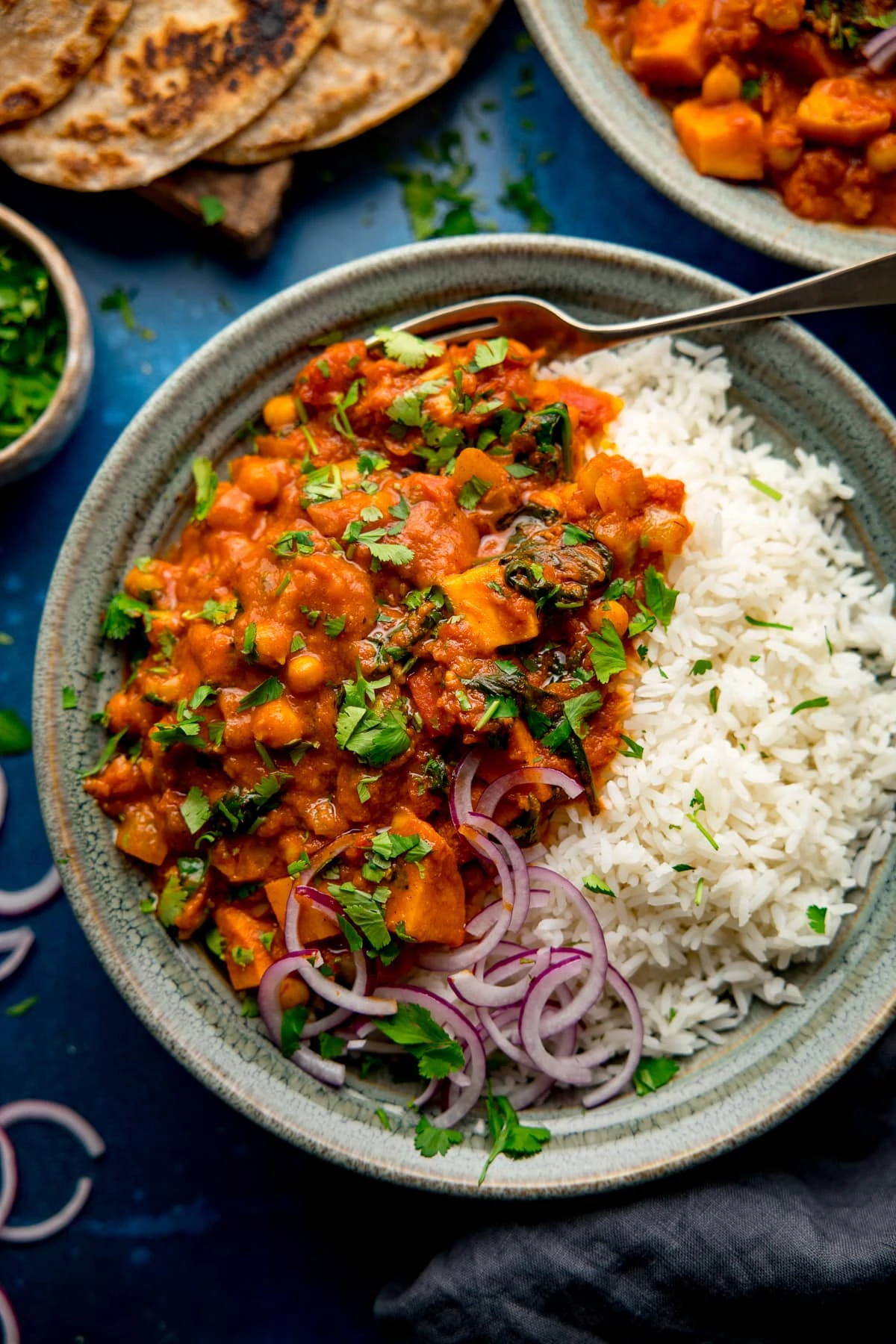 chickpea and sweet potato curry with rice in a green bowl