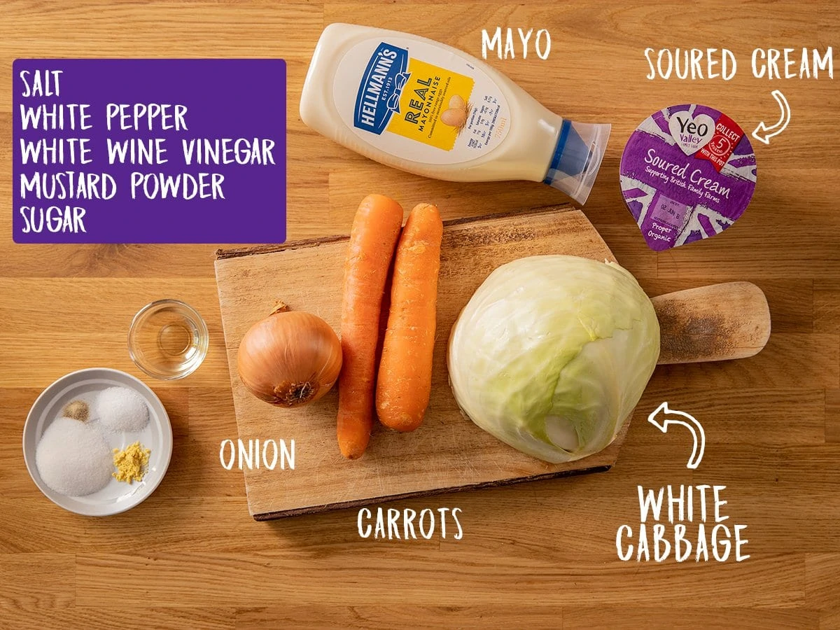 Ingredients for making creamy coleslaw in a wooden table