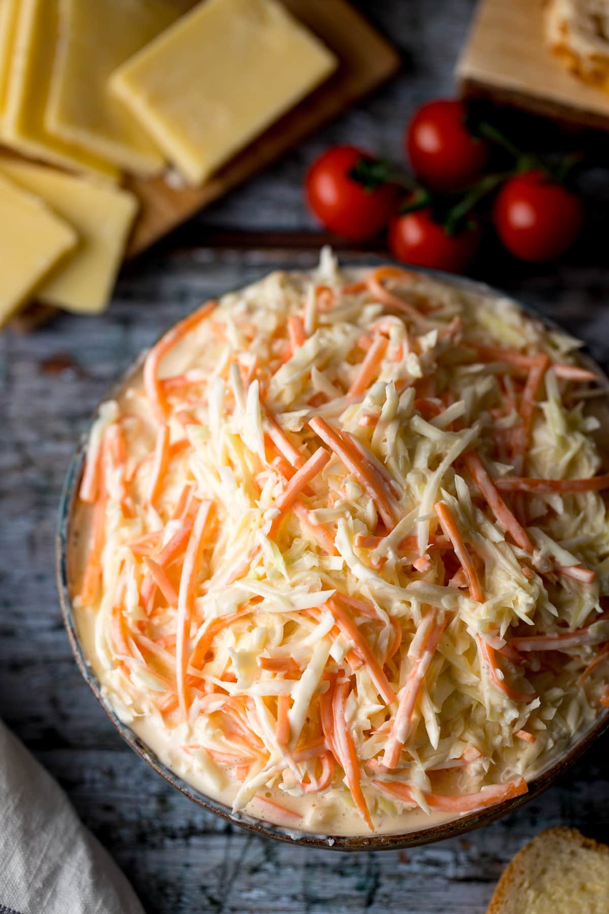 Overhead image of creamy coleslaw surrounded by picnic food