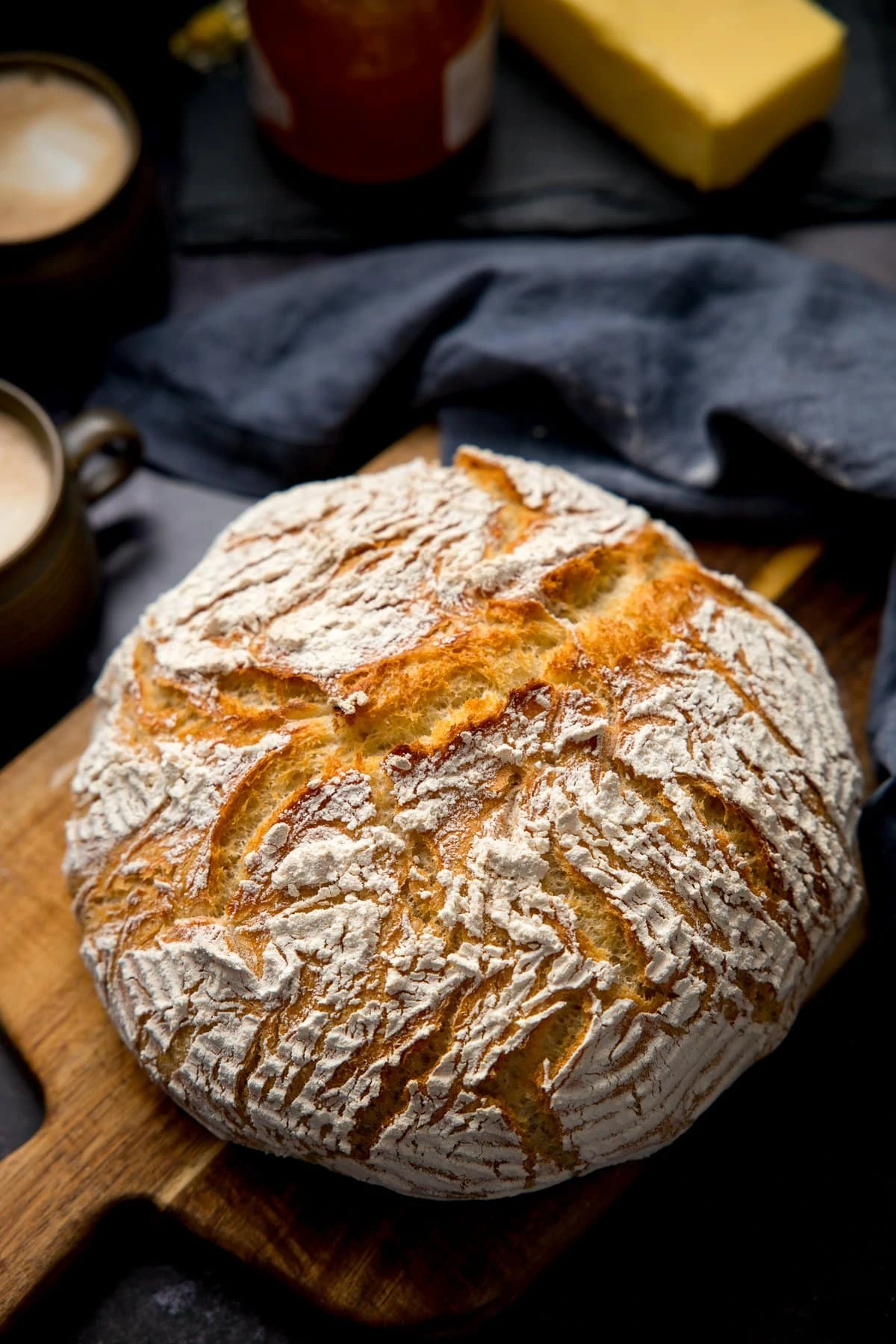 Overhead image of a loaf of homemade artisan bread on a wooden board