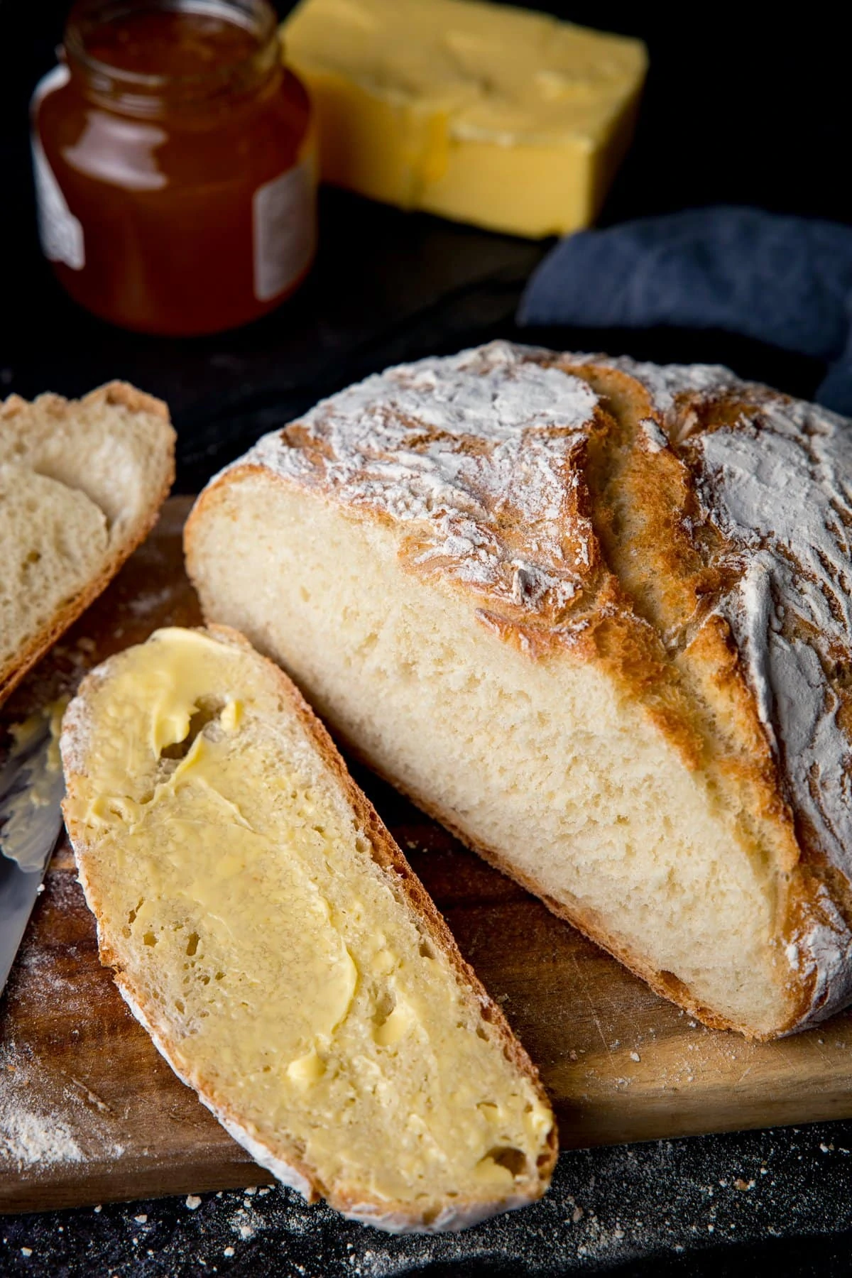 Homemade artisan bread slice open and slice spread with butter